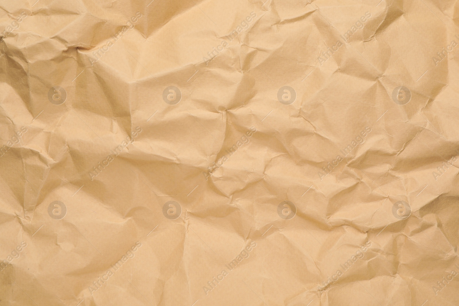 Photo of Texture of brown crumpled paper as background, closeup