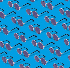 Image of Many stylish sunglasses on light blue background. Seamless pattern design