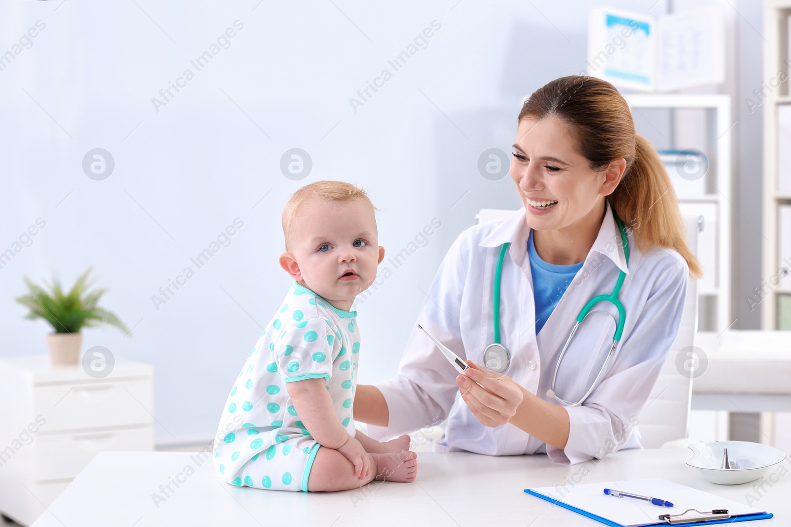 Photo of Children's doctor checking baby's temperature in hospital