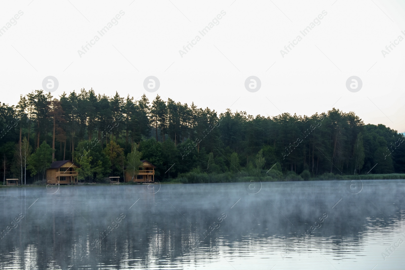 Photo of Beautiful landscape with forest and houses near lake. Camping season
