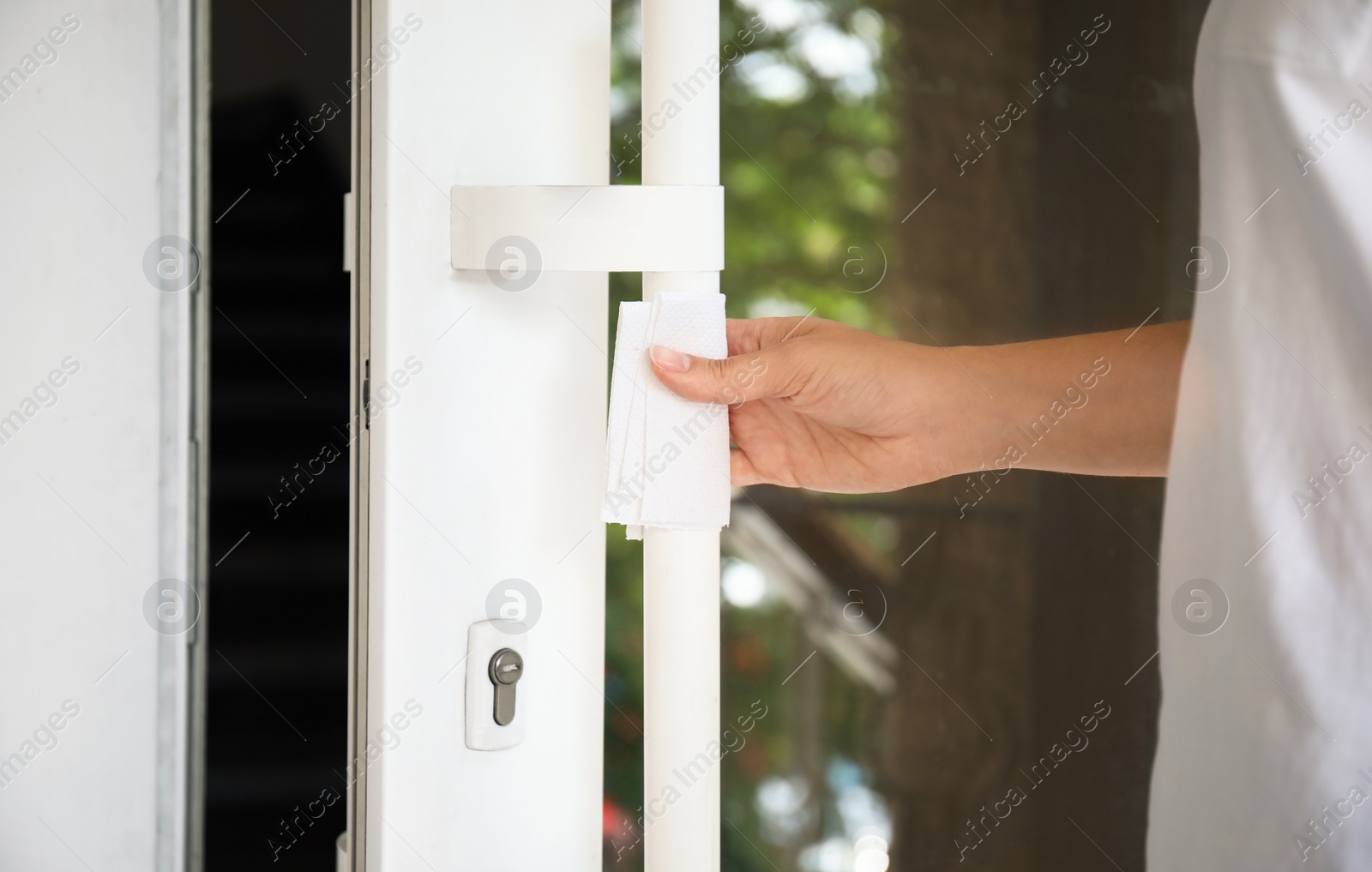 Photo of Woman using tissue paper to open door, closeup