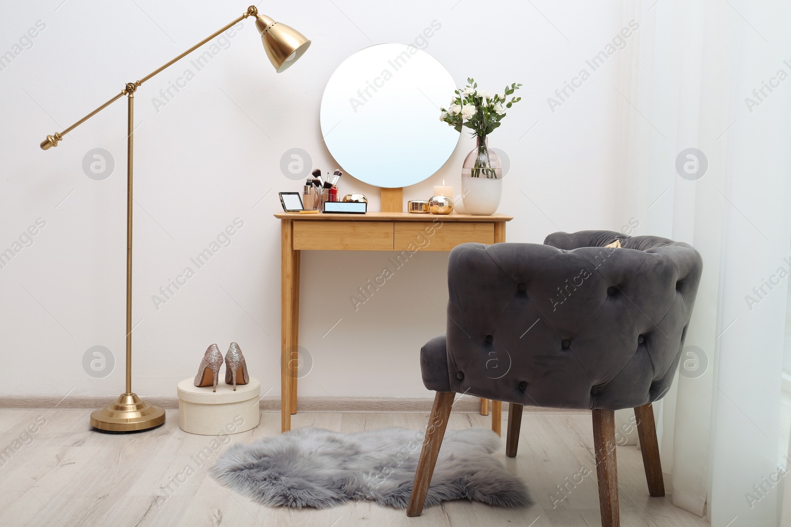 Photo of Stylish room interior with wooden dressing table and armchair