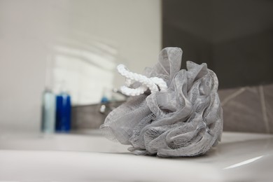 Grey shower puff on washbasin in bathroom, closeup