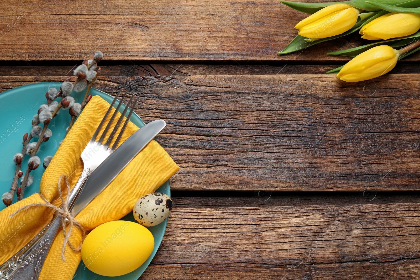 Photo of Festive Easter table setting with beautiful tulips and willow branches, flat lay. Space for text