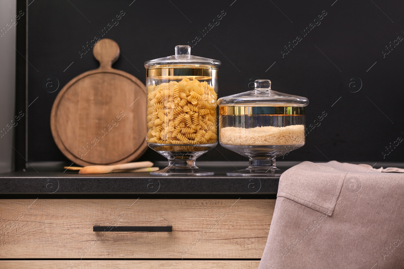 Photo of Raw cereals on black table in modern kitchen