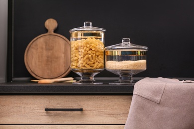 Photo of Raw cereals on black table in modern kitchen