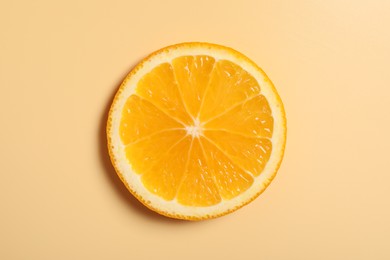 Photo of Slice of juicy orange on beige background, top view