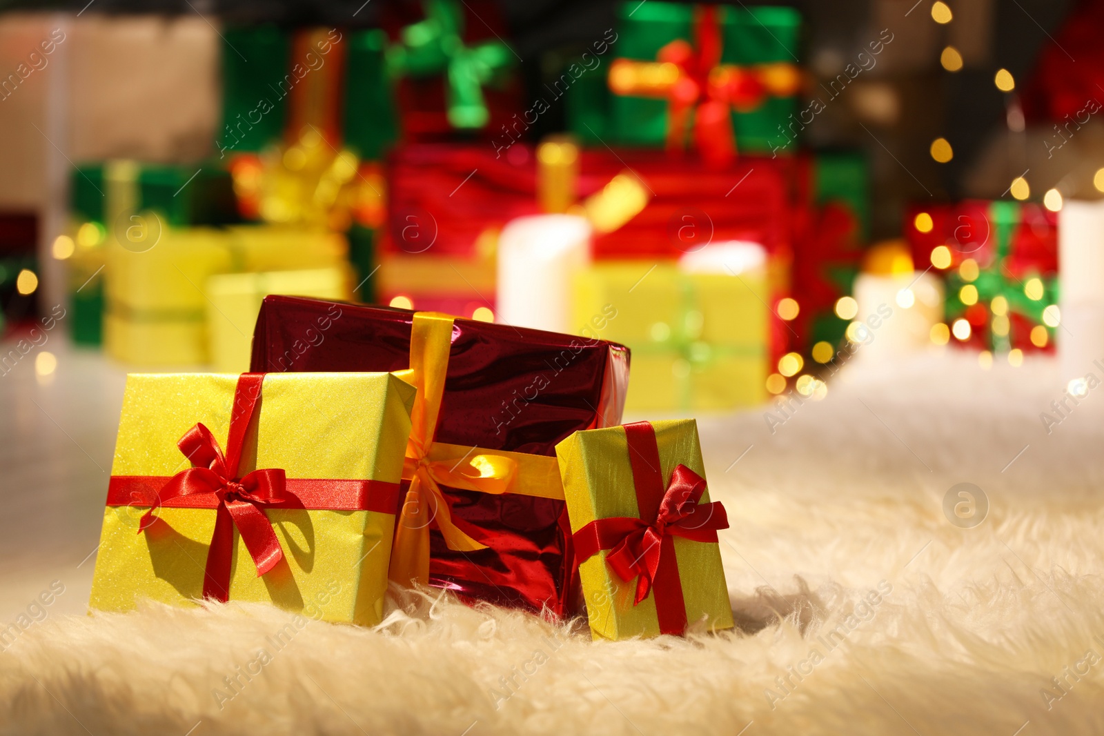 Photo of Beautiful Christmas gifts on furry carpet in room