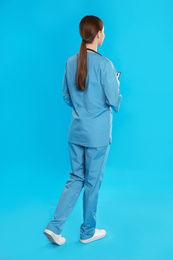 Doctor in uniform walking on blue background