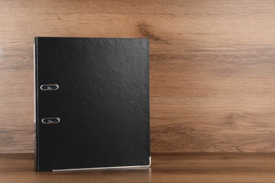 Black office folder on wooden table, space for text