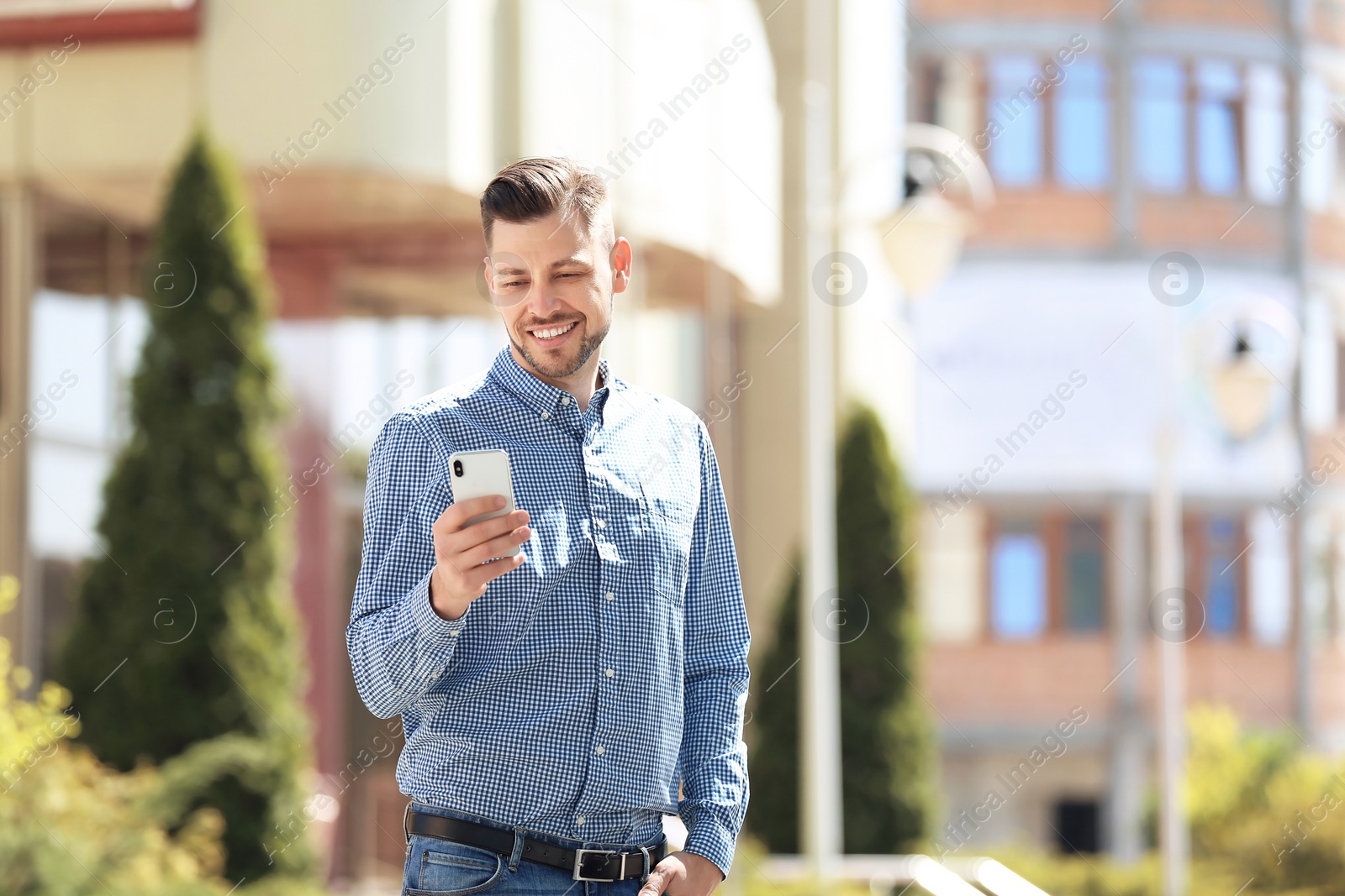 Photo of Portrait of young man with smartphone outdoors