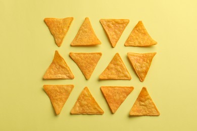 Flat lay composition of tortilla chips (nachos) on yellow background