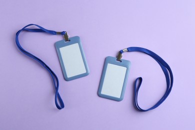 Photo of Blank badges on violet background, flat lay. Mockup for design