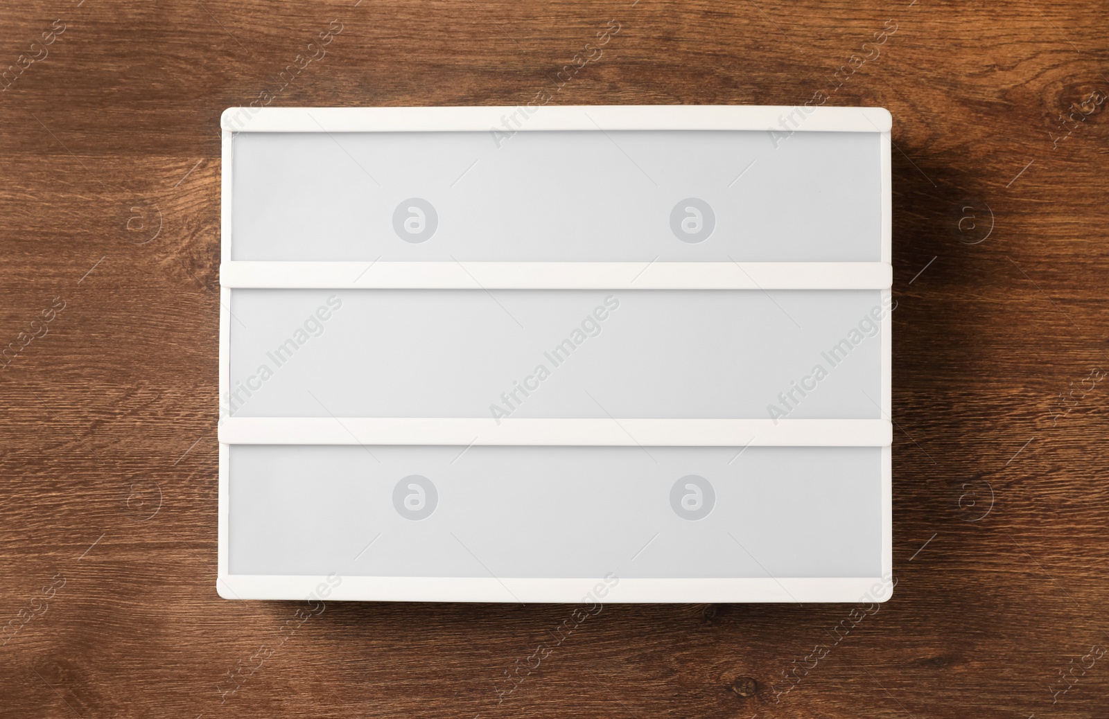 Photo of Blank letter board on wooden table, top view. Mockup for design