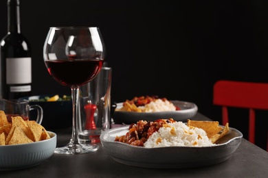 Photo of Tasty chili con carne served with rice on gray table. Dinner in restaurant