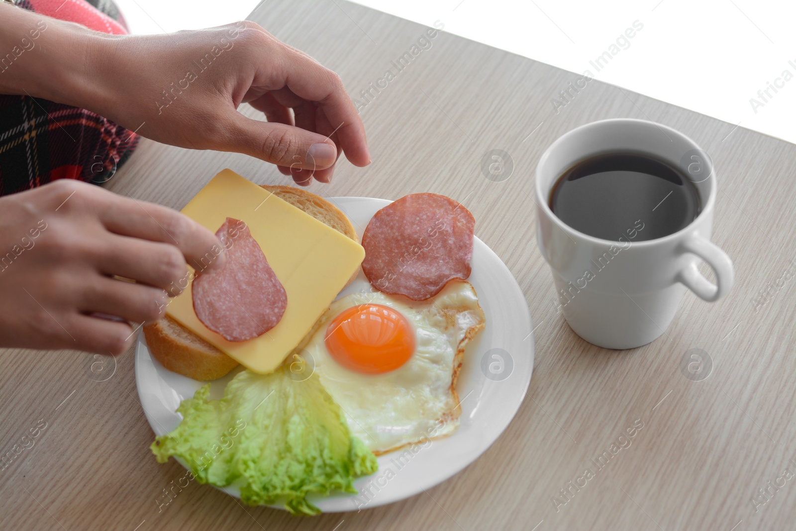 Photo of Woman preparing tasty nutritious breakfast at wooden table against white background, closeup. Good morning