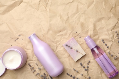 Photo of Flat lay composition with hair care cosmetic products on crumpled paper. Space for text