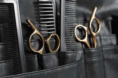 Hairdresser tools. Professional scissors and combs in leather organizer, closeup