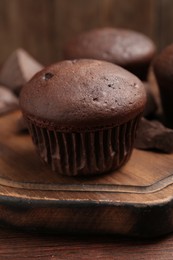 Photo of Delicious chocolate cupcake on wooden board, closeup
