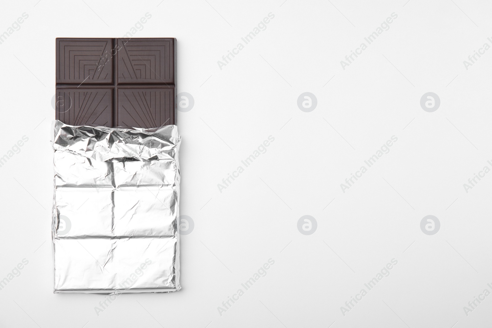 Photo of Tasty chocolate bar on white background, top view
