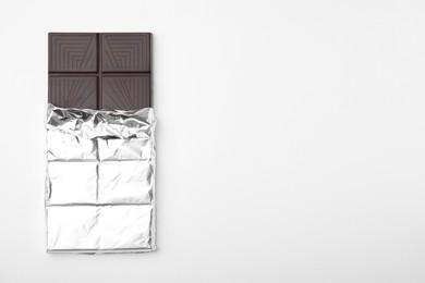 Photo of Tasty chocolate bar on white background, top view