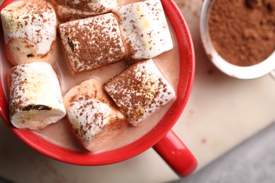 Photo of Cup of aromatic hot chocolate with marshmallows and cocoa powder on table, top view