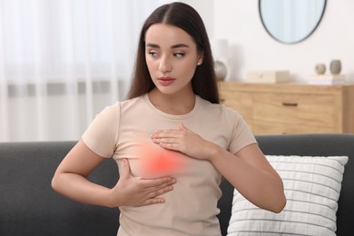 Image of Beautiful young woman doing breast self-examination at home