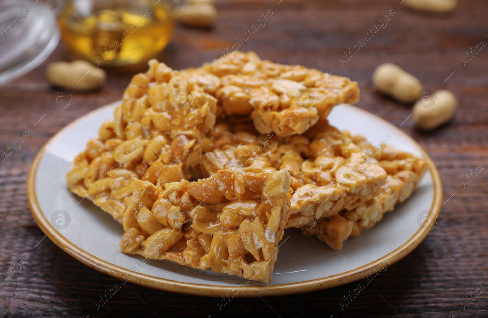 Photo of Delicious peanut bars (kozinaki) on wooden table, closeup