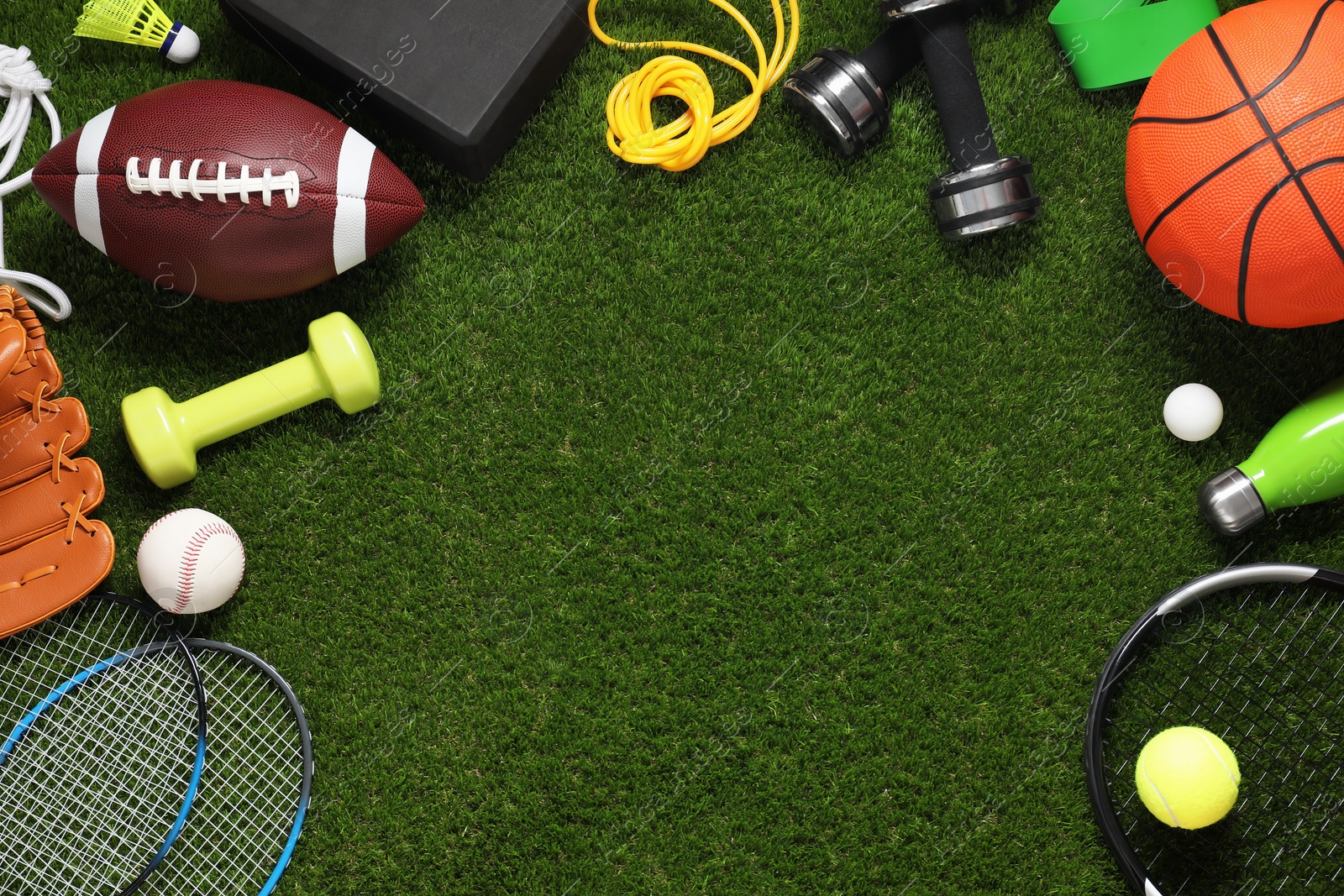 Photo of Different sport tools on green grass, flat lay. Space for text