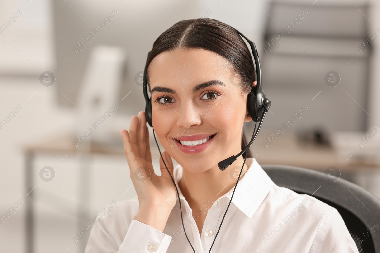 Photo of Hotline operator with headset working in office