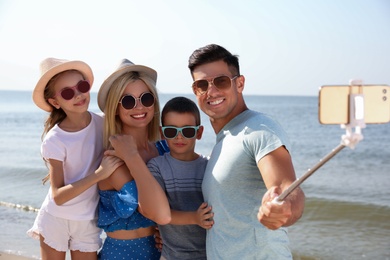 Happy family taking selfie at beach on sunny day