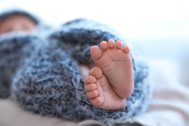 Newborn baby lying on plaid, closeup of legs