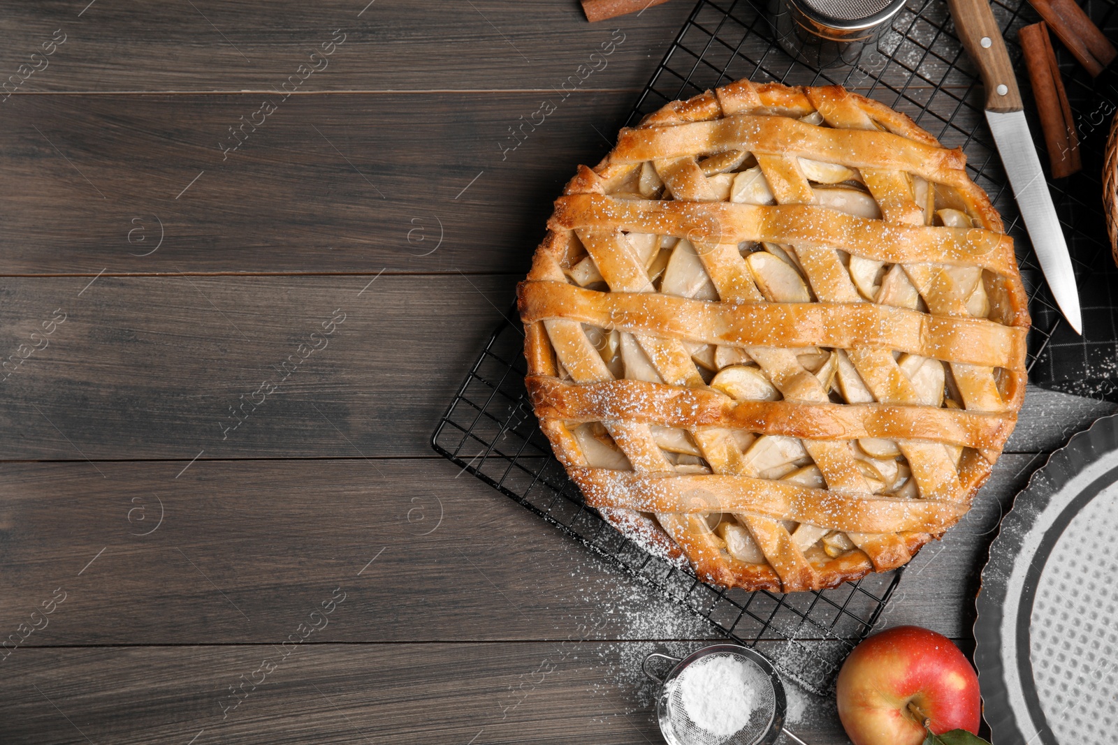 Photo of Delicious traditional apple pie on wooden table, flat lay. Space for text