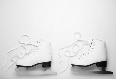 Photo of Pair of ice skates on white background, top view. Space for text