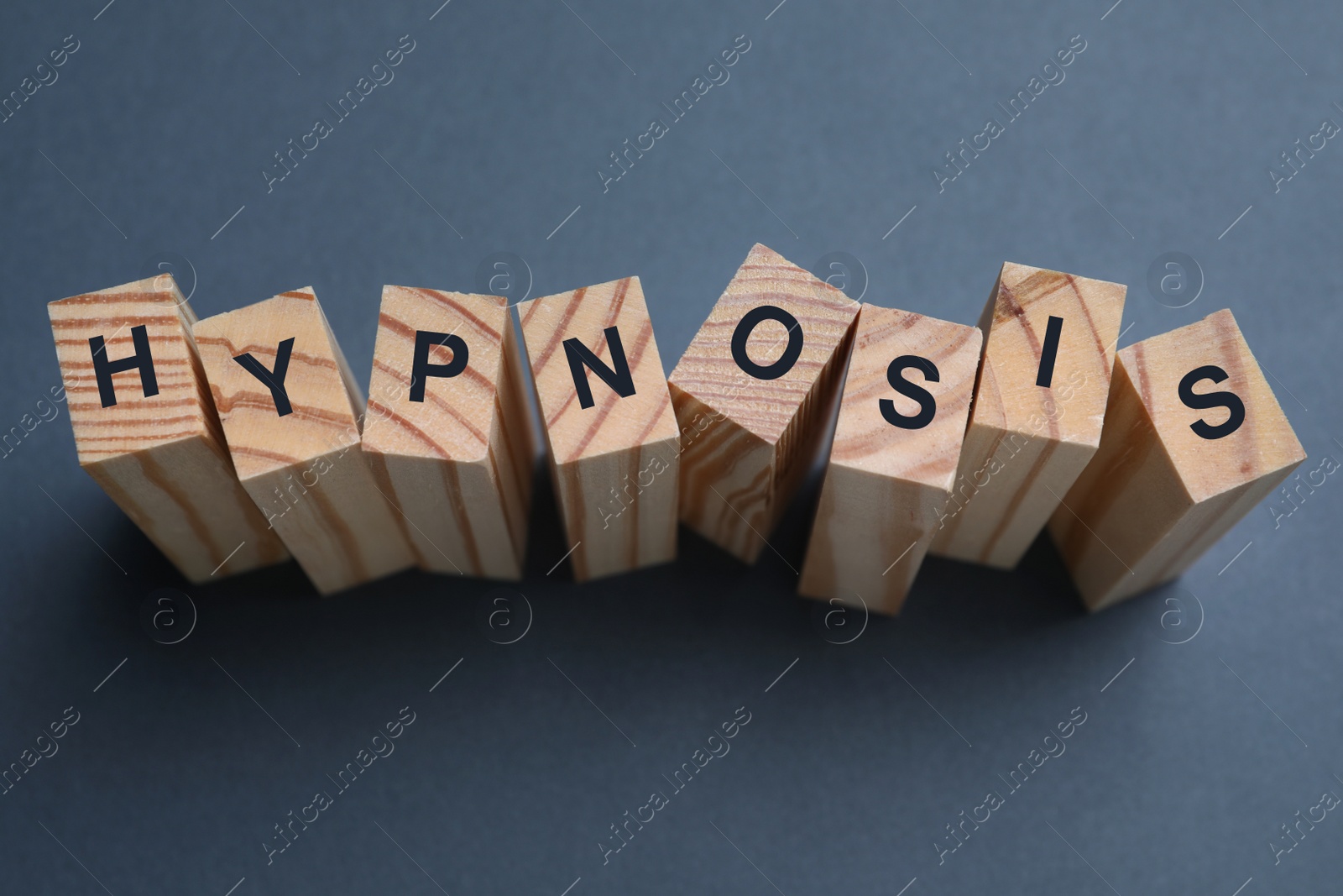 Photo of Wooden blocks with word HYPNOSIS on dark background, above view