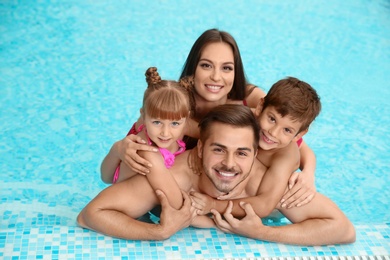 Photo of Happy family resting in swimming pool with refreshing water