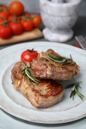 Photo of Delicious fried meat with rosemary and tomato on plate, closeup