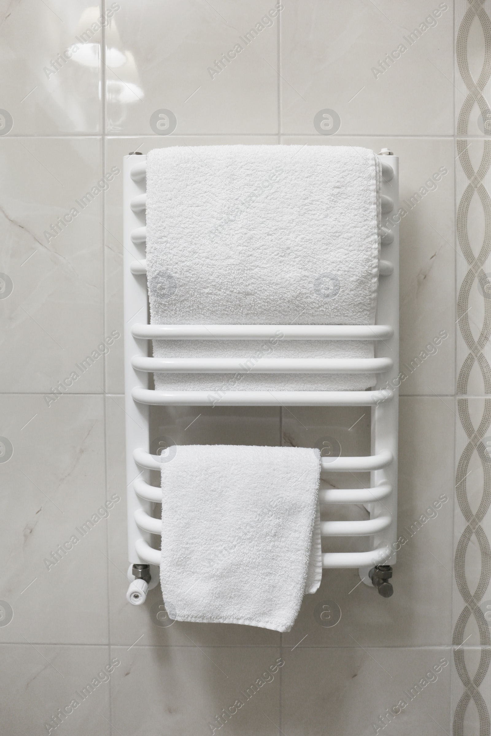 Photo of Dryer with clean white towels on wall