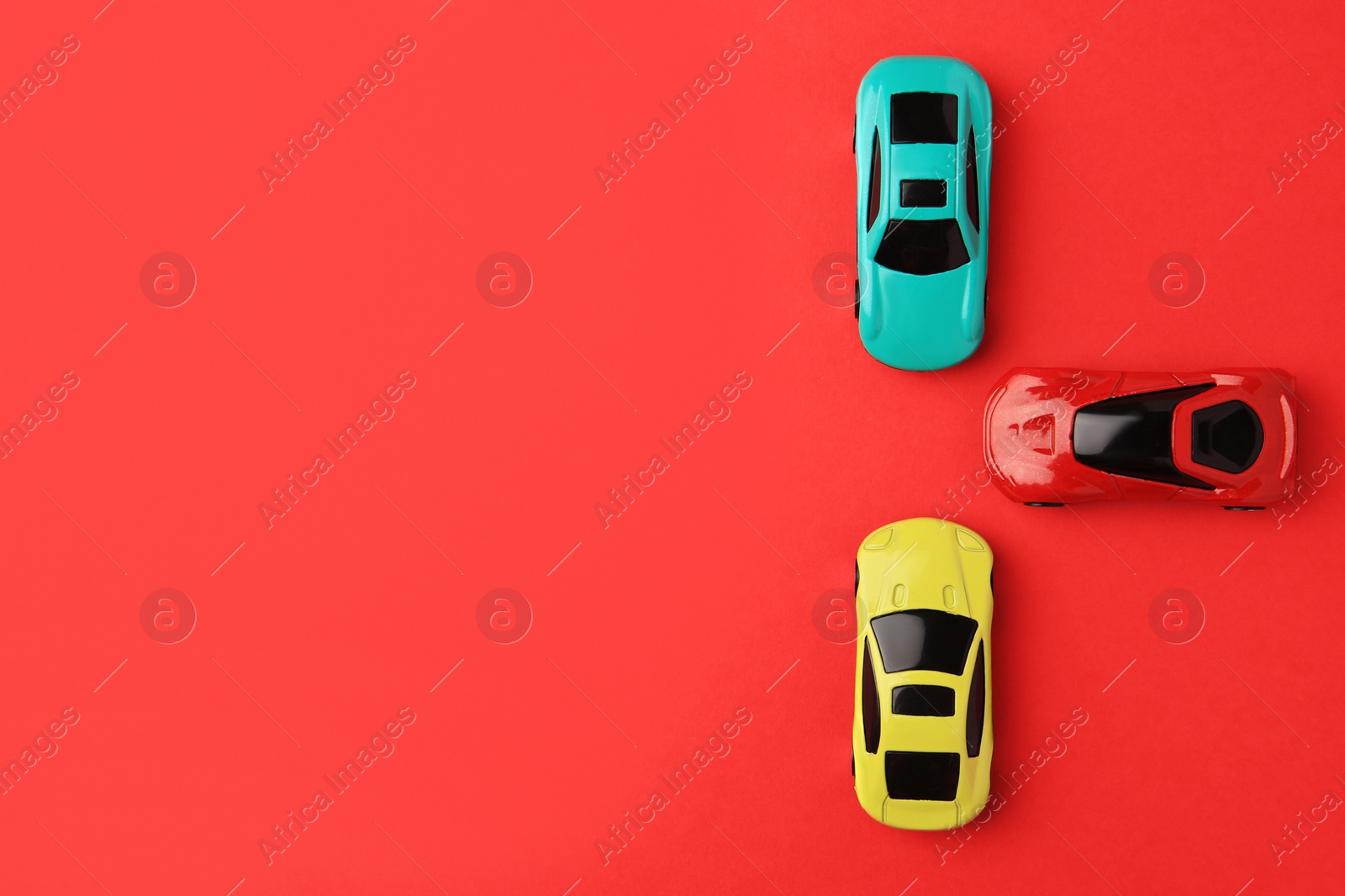 Photo of Different bright cars on red background, flat lay. Space for text