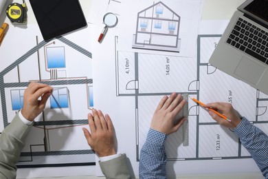 Photo of Architects working with construction drawings at table, top view