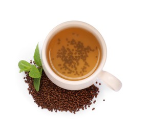Cup of aromatic buckwheat tea, granules and mint on white background, top view