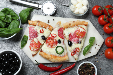 Photo of Flat lay composition with pieces of delicious pizza Diablo on dark background