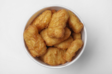 Photo of Bucket with tasty chicken nuggets on white background, top view