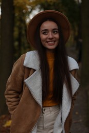 Photo of Portrait of beautiful young woman in autumn park