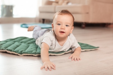 Photo of Adorable little baby crawling on floor at home
