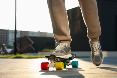 Man riding skateboard in stylish sneakers outdoors, closeup. Space for text