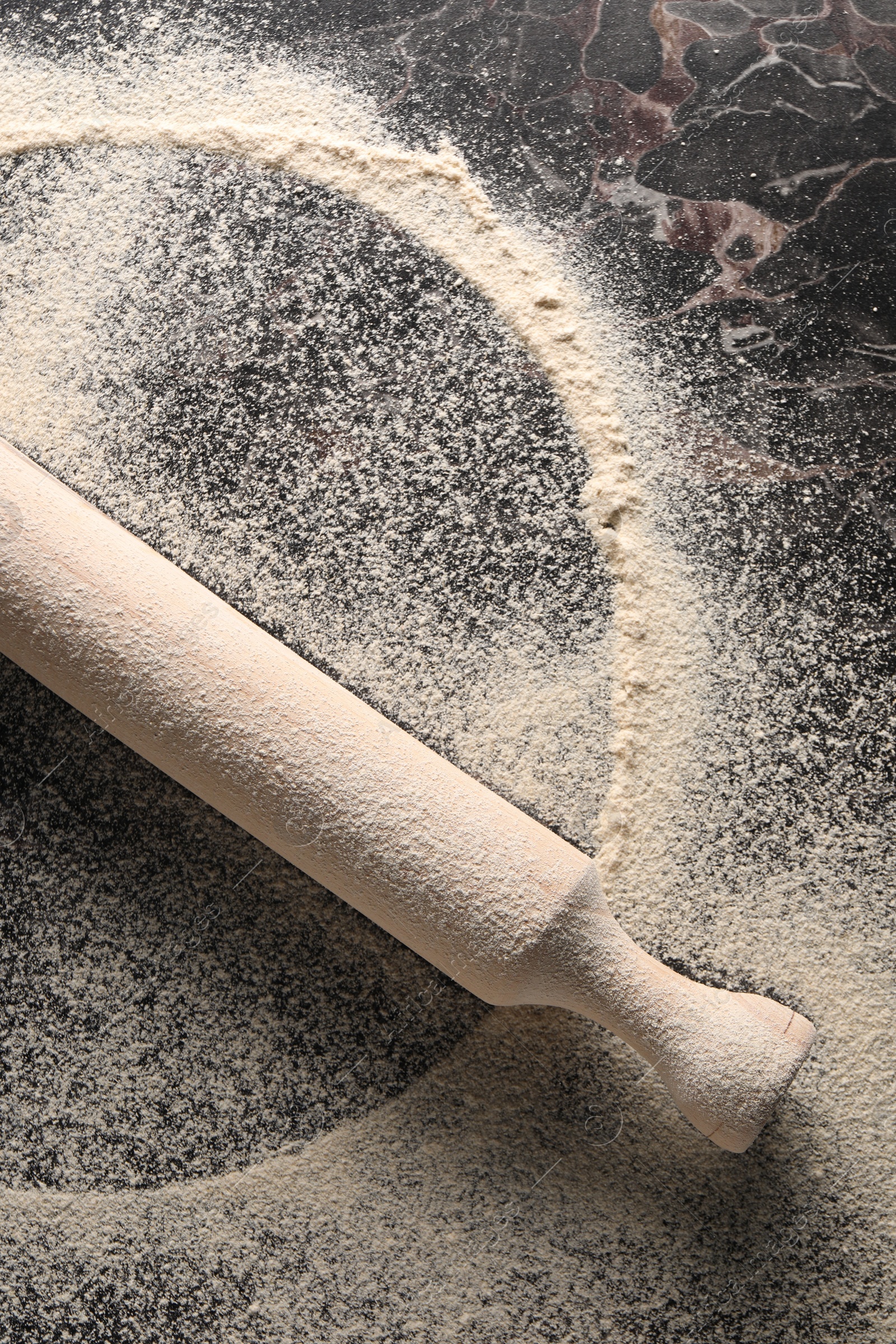 Photo of Flour and rolling pin on table, top view