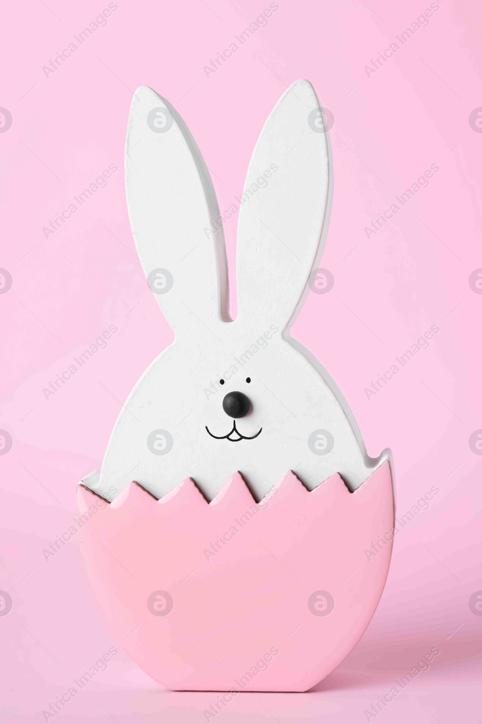 Photo of Bunny figure as Easter decor on pink background