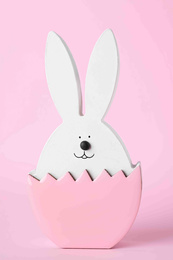 Photo of Bunny figure as Easter decor on pink background