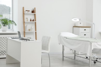 Photo of Modern interior of dermatologist's office with examination table